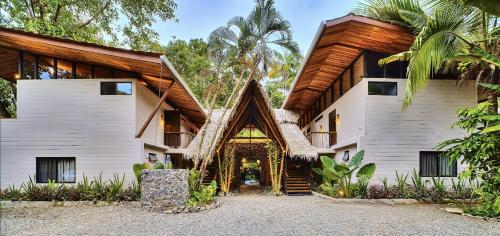 an exterior view of a house with a wooden roof at Conga Boutique Hotel in Puerto Viejo