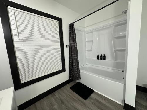 a bathroom with a tub and a shower with a window at Fully Renovated Modern 4Bedroom 3Bath Home Close to Downtown Cleveland Fully Furnished in Cleveland