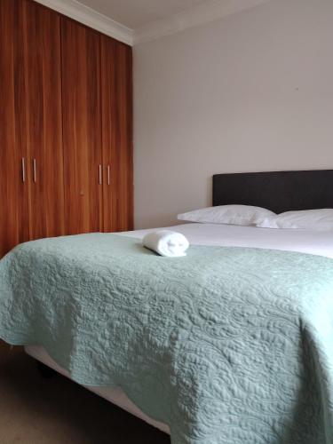 a bed with a green blanket and a wooden cabinet at The Pad in Albinia