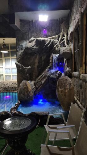 a waterfall in the middle of a room with a pool at استراحة شاطئ ابحر الجنوبيه south obhur beatch chalet in Jeddah
