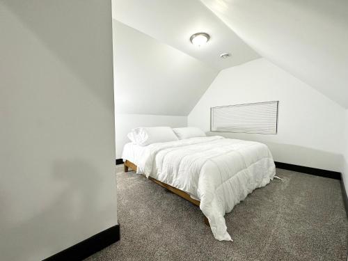 a white bedroom with a bed with white sheets at Fully Renovated Modern 4Bedroom 3Bath Home Close to Downtown Cleveland Fully Furnished in Cleveland