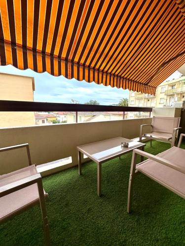 a balcony with a table and chairs and an umbrella at Studio Kialeo près de la plage avec parking voiture in Roquebrune-Cap-Martin