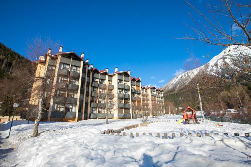 un hôtel dans la neige avec une montagne en arrière-plan dans l'établissement Résidence Grand Roc - Campanules 308 - Happy Rentals, à Chamonix-Mont-Blanc