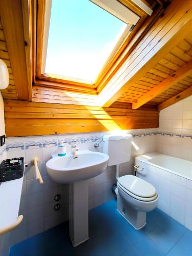 a bathroom with a sink and a toilet and a skylight at La Meridiana sul Lago in Abbadia Lariana