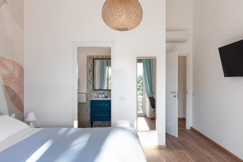 a white bedroom with a bed and a mirror at B&B Vitruvio Suites in Formia