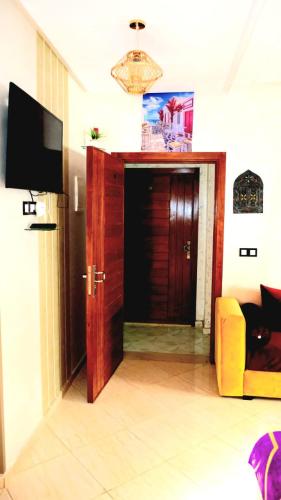 a living room with a door and a yellow couch at Apprt Ennakhil 3 in El Jadida
