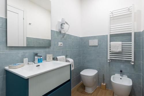 a bathroom with a sink and a toilet and a mirror at B&B Vitruvio Suites in Formia