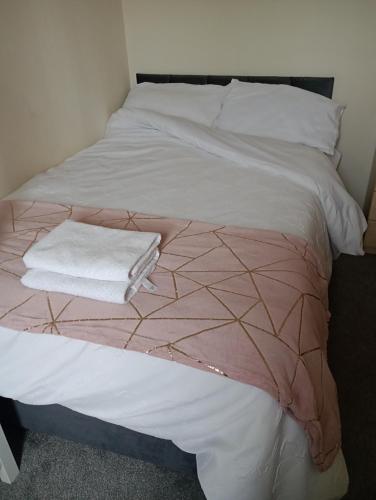 a white bed with a pink blanket on it at Emerson Valley Lettings in Shenley Church End