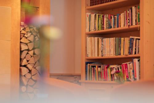 a book shelf full of books in a room at Berghotel zum Zirm in Collalbo