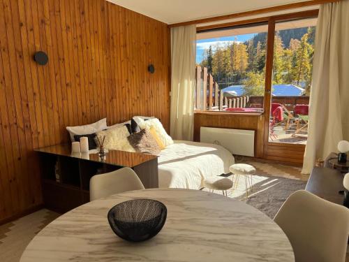 une chambre avec un lit, une table et une fenêtre dans l'établissement Studio grande terrasse Pra loup 1600, à Uvernet