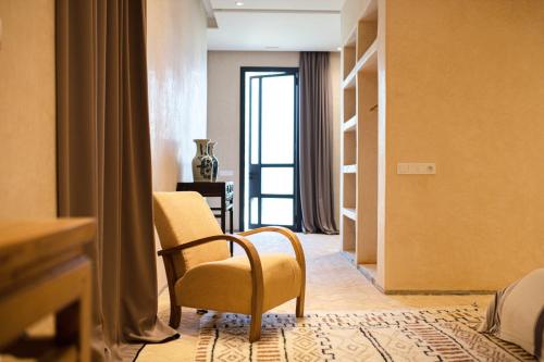 a room with a chair and a room with a window at Atlas Retreat Luxury Bed and Breakfast in Beni Mellal