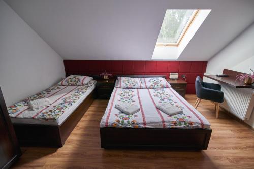 a bedroom with two beds and a desk and a window at Agroturystyka Olszynka in Skopanie