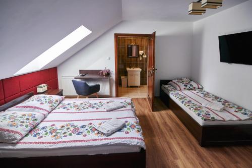 a bedroom with two beds and a tv on the wall at Agroturystyka Olszynka in Skopanie