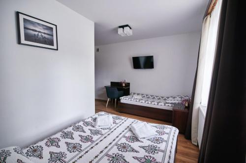 a room with two beds and a tv in it at Agroturystyka Olszynka in Skopanie