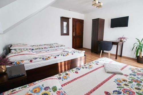 a bedroom with two beds and a desk in it at Agroturystyka Olszynka in Skopanie