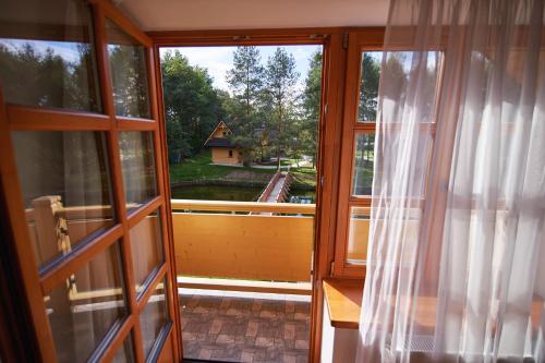 an open window with a view of a house at Agroturystyka Olszynka in Skopanie
