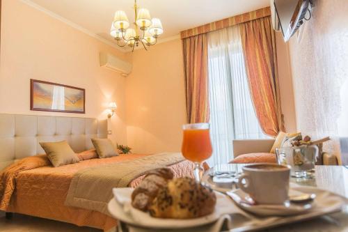 ein Schlafzimmer mit einem Bett und einem Tisch mit einem Tablett mit Essen in der Unterkunft Hotel Aquila in Orte