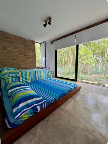 a bedroom with a bed and a large window at Casa campestre Lago Calima in Calima