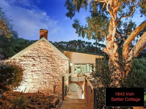 a brick house with a staircase leading to a tree at Galway Cottage ADL Retaining Pty Ltd trading as Murphys Coittages in Willunga