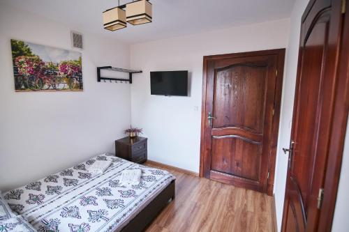 a bedroom with a bed and a wooden door at Agroturystyka Olszynka in Skopanie