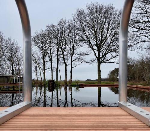 a wooden bridge over a body of water at Wiltsangh Texel Tuinsuite Black in De Waal