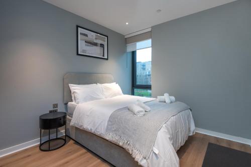 a bedroom with a large bed with a window at Alto Apartment - Modern Comfort & Prime Location in London