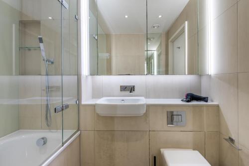 a bathroom with a sink and a toilet and a shower at Alto Apartment - Modern Comfort & Prime Location in London
