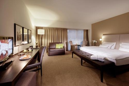 a hotel room with a large bed and a desk at Lindner Hotel Antwerp, part of JdV by Hyatt in Antwerp