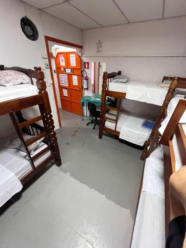 a room with three bunk beds and a desk at COACHHOSTEL7 in Sao Paulo