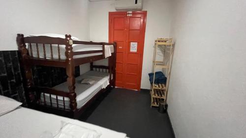 a room with a bunk bed and a red door at COACHHOSTEL7 in Sao Paulo