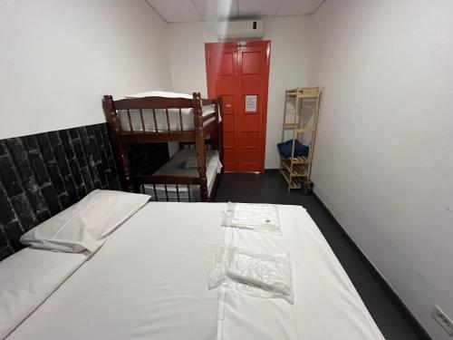 a room with a bed and two chairs and a red door at COACHHOSTEL7 in Sao Paulo