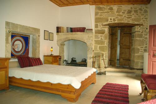 a bedroom with a bed and a stone wall at Sior Nikoletos in Vóroi