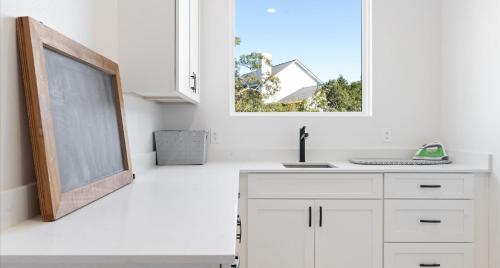 a white kitchen with a chalkboard and a window at Tranquil Lakefront Villa - Perfect for Weekdays or Weekends in South Jonestown Hills