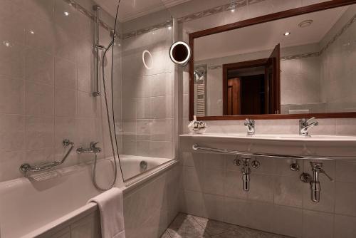 a bathroom with a shower and a sink and a tub at Hotel d'Allèves in Geneva