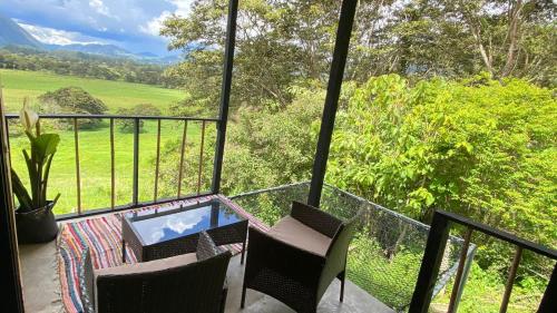 a balcony with chairs and a table and a view at Cabaña2 con hermosa vista al valle in Oxapampa