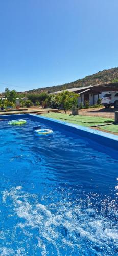 a large pool of blue water in a yard at Cabañas Tricahue in El Manzano
