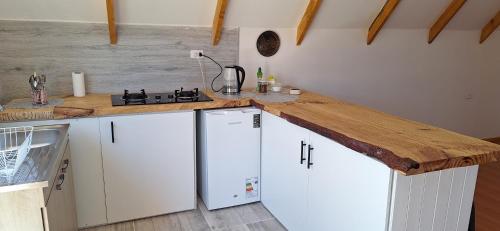 a kitchen with white cabinets and a wooden counter top at Cabañas Tricahue in El Manzano