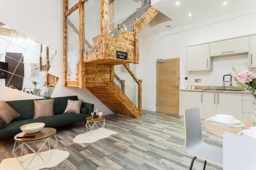 ブラッドフォードにあるBradford Luxury Central Apartmentのリビングルーム(緑のソファ付)、キッチンが備わります。