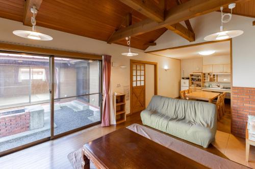 a living room with a couch and a large window at 舞鶴ふるるファームコテージ in Maizuru