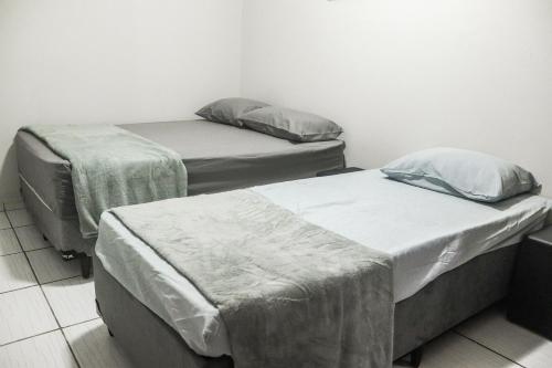 a room with three beds in a room at Casa Caminho da fé a menos de 10 minutos da basílica in Potim