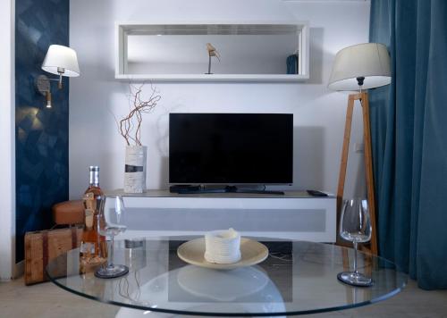 un salon avec une télévision et une table en verre dans l'établissement Le Panorama - Cannes Beach, à Cannes
