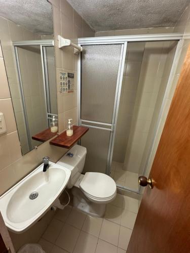 a bathroom with a white toilet and a sink at Eco Lodge La Juanita in Manizales