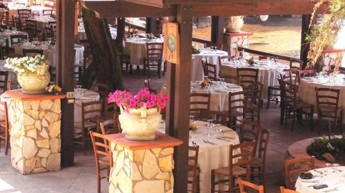a group of tables and chairs with vases of flowers at Hotel Club Torre Capovento in Sperlonga
