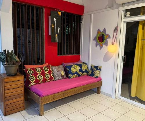 a couch sitting on a porch with colorful pillows at Villa Pointe La Rose in Le Robert