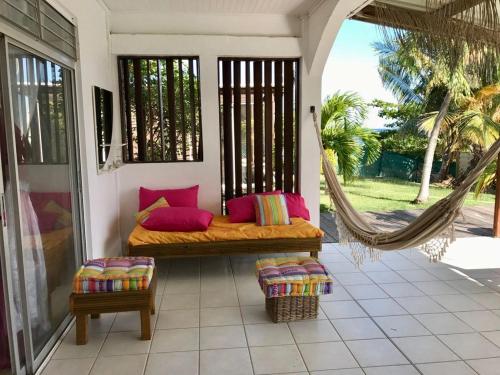a porch with a bed and a hammock at Villa Pointe La Rose in Le Robert