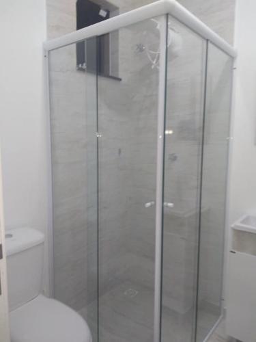 a glass shower in a bathroom with a toilet at Casa Rebello - Pousada in Itajaí