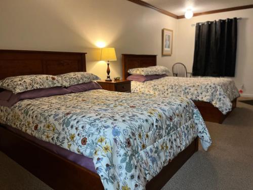 a bedroom with two beds and a lamp at Arthur Country Inn in Arthur