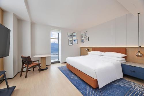a bedroom with a bed and a desk and a tv at Four Points by Sheraton Dali, Erhai in Dali