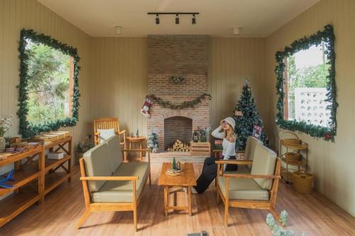 una mujer sentada en una sala de estar con chimenea en THUNWA the CAMPSITE, en Khao Kho