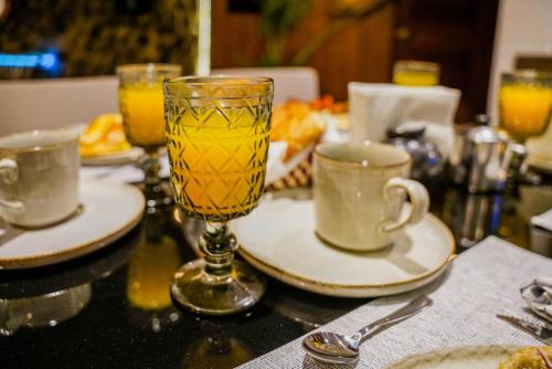 a table with a glass of orange juice and two cups at El Edén in Zipolite